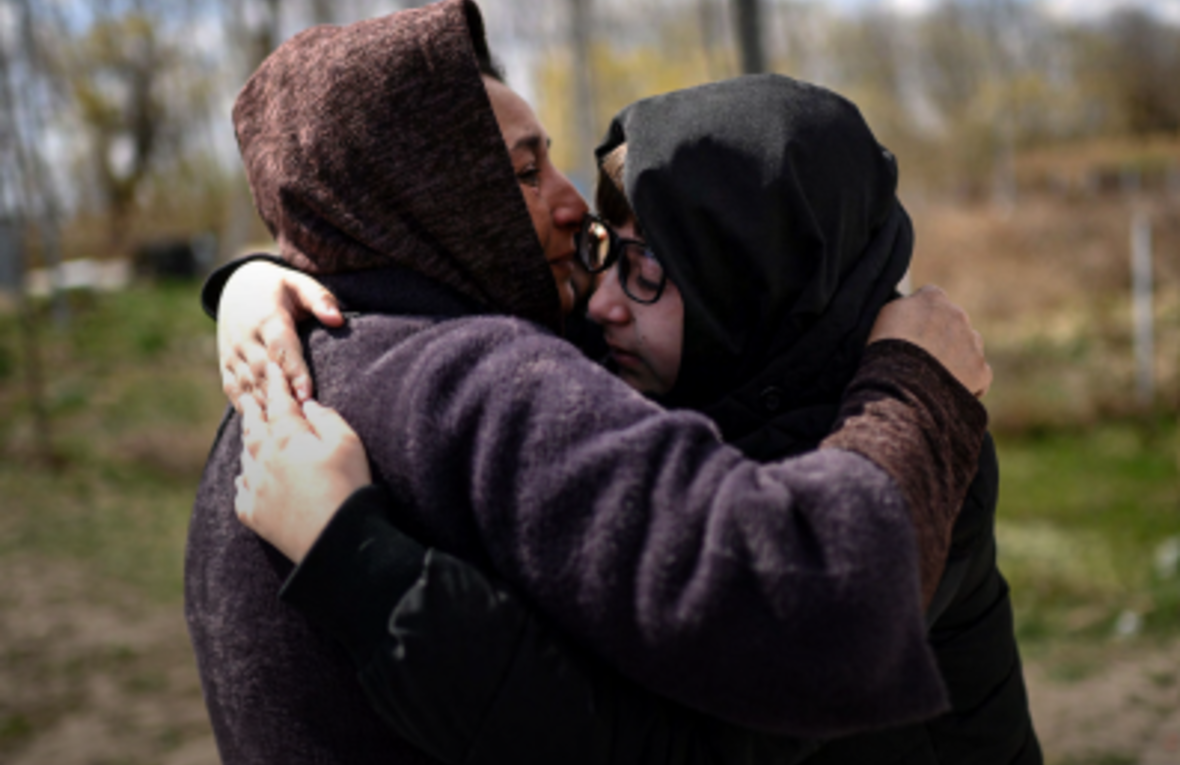 Cover of "Mapping of good practices in family reunification for unaccompanied and separated children and adolescents" report featuring two people embrace after reuniting on their way back home at a border crossing